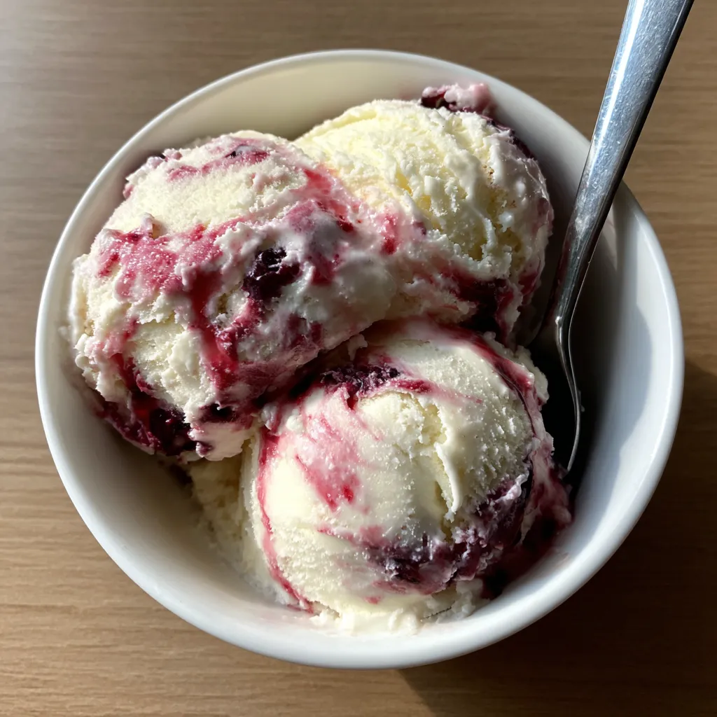 A bowl of ice cream with berry swirl.