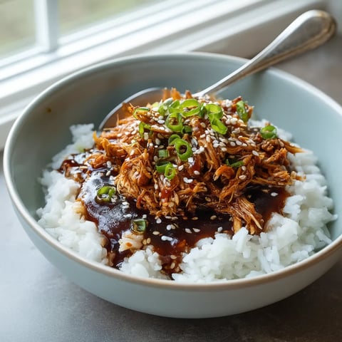 A bowl of rice with meat and vegetables.